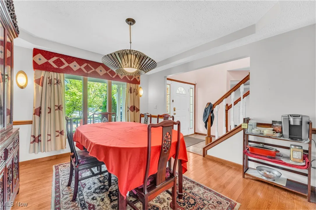 formal dining with tray ceiling and rich hardwood floors