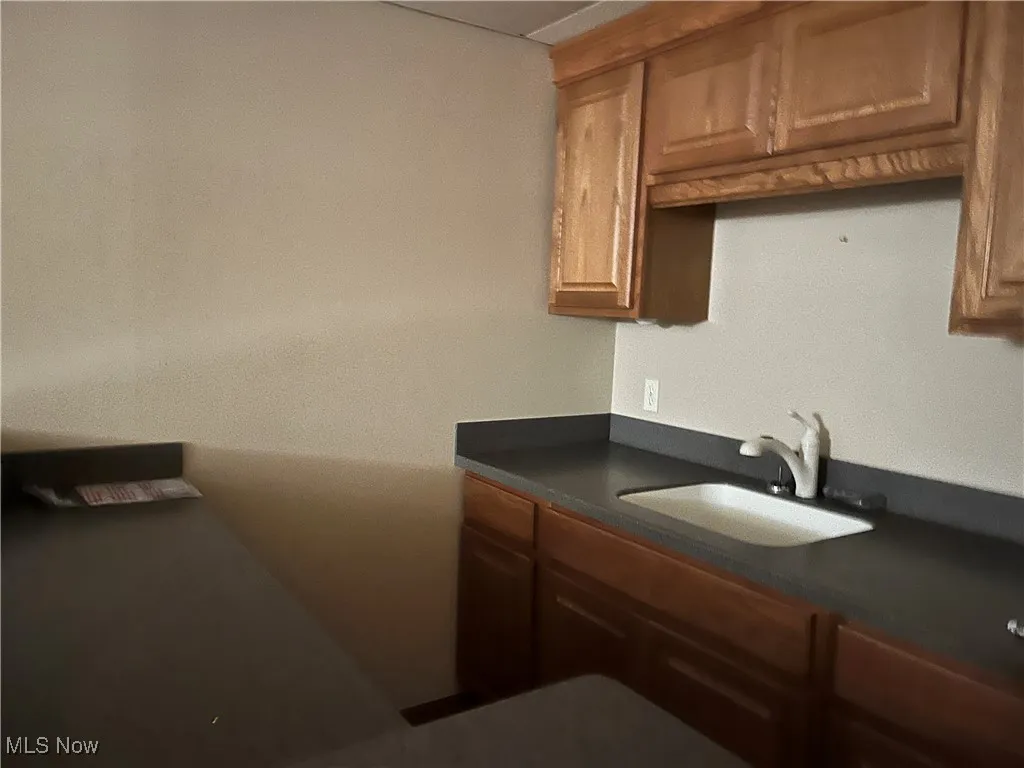 Kitchen with dark countertops, a sink, and brown cabinets
