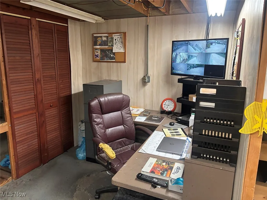 Office space with unfinished concrete floors and wooden walls