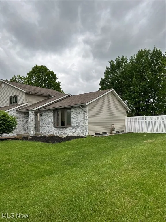 View of side of property with a shingled roof