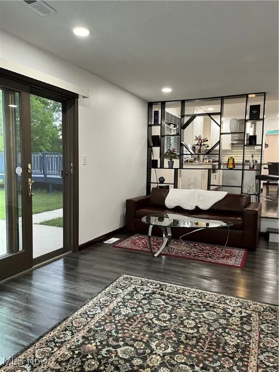 Living area with wood finished floors, baseboards, and recessed lighting