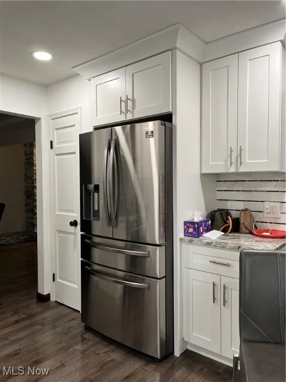 Kitchen with stainless steel fridge with ice dispenser, dark wood-style flooring, white cabinetry, light countertops, and recessed lighting