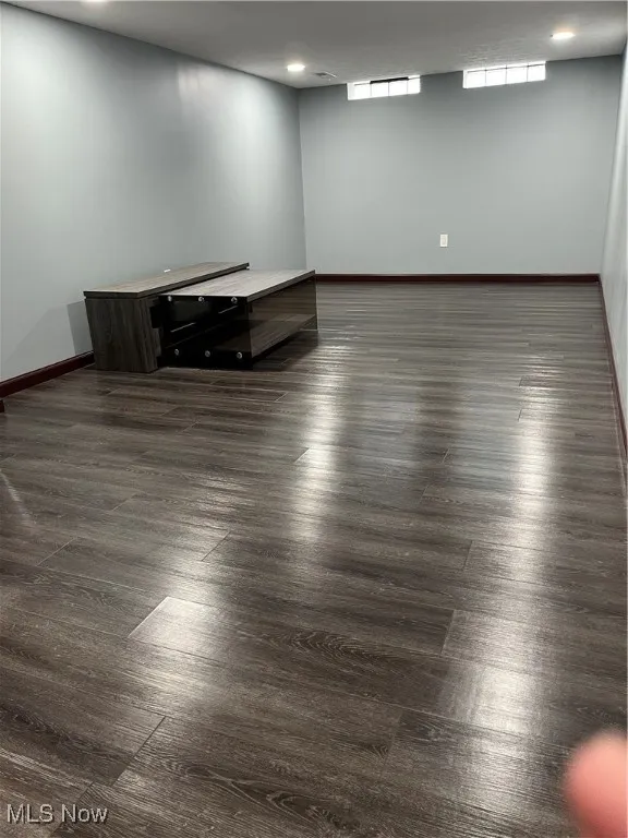 Empty room featuring baseboards, recessed lighting, and dark wood finished floors