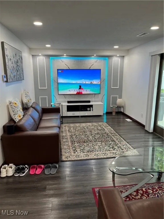 Living room featuring wood finished floors, baseboards, and recessed lighting