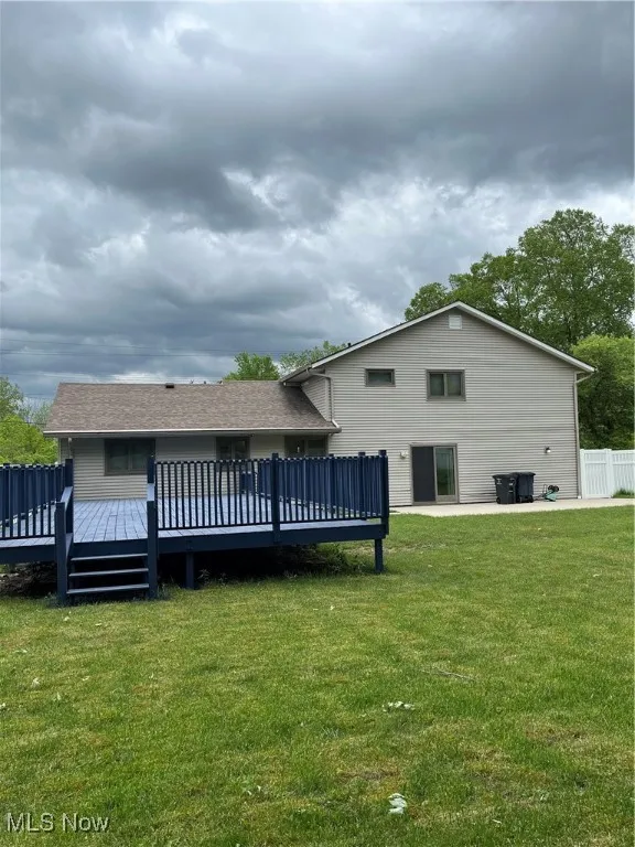 Back of house featuring a deck and a yard