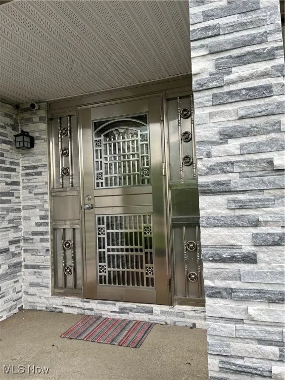View of exterior entry featuring stone siding