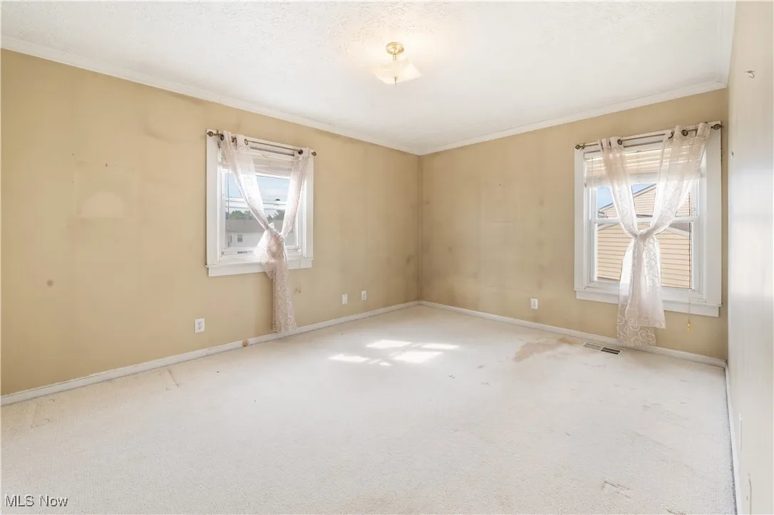 Bedroom with ornamental molding, carpet flooring, and baseboards