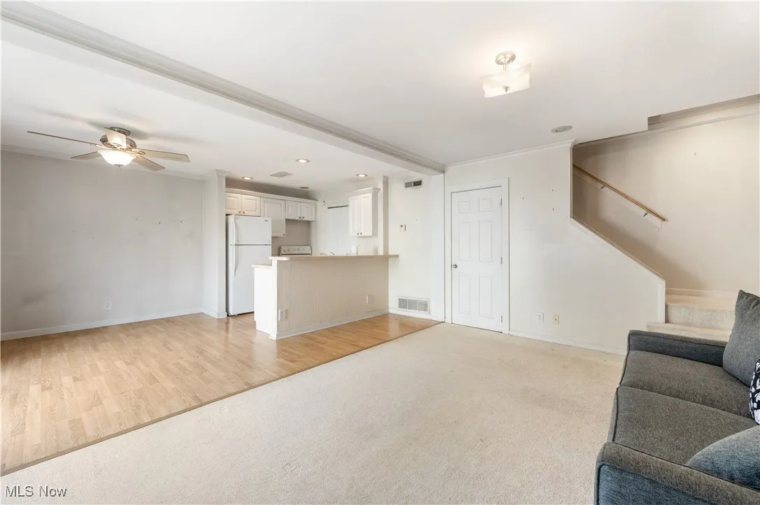 Living area with stairs, baseboards, ceiling fan, recessed lighting, and crown molding