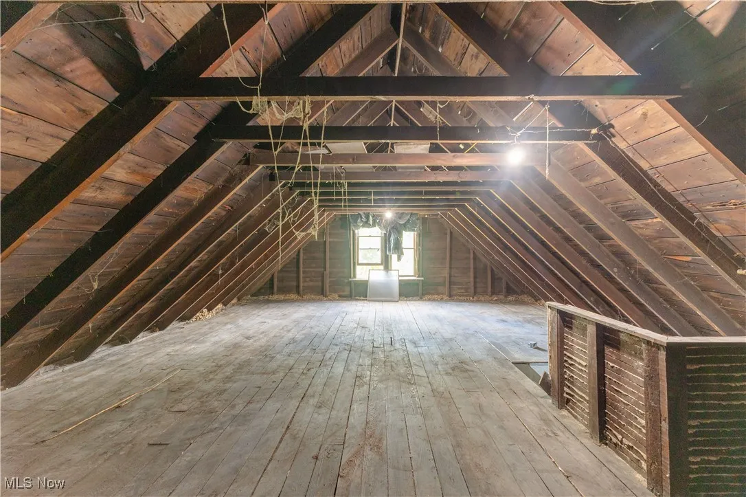 Unfinished attic with an upstairs landing