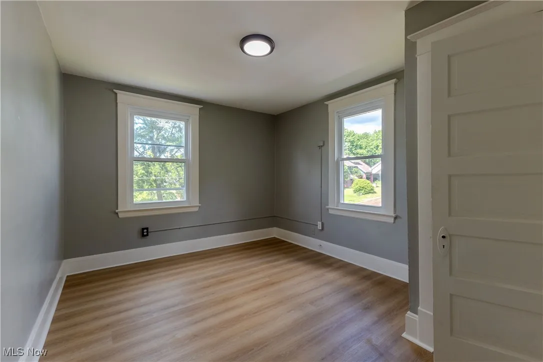 Spare room featuring light wood-type flooring and baseboards