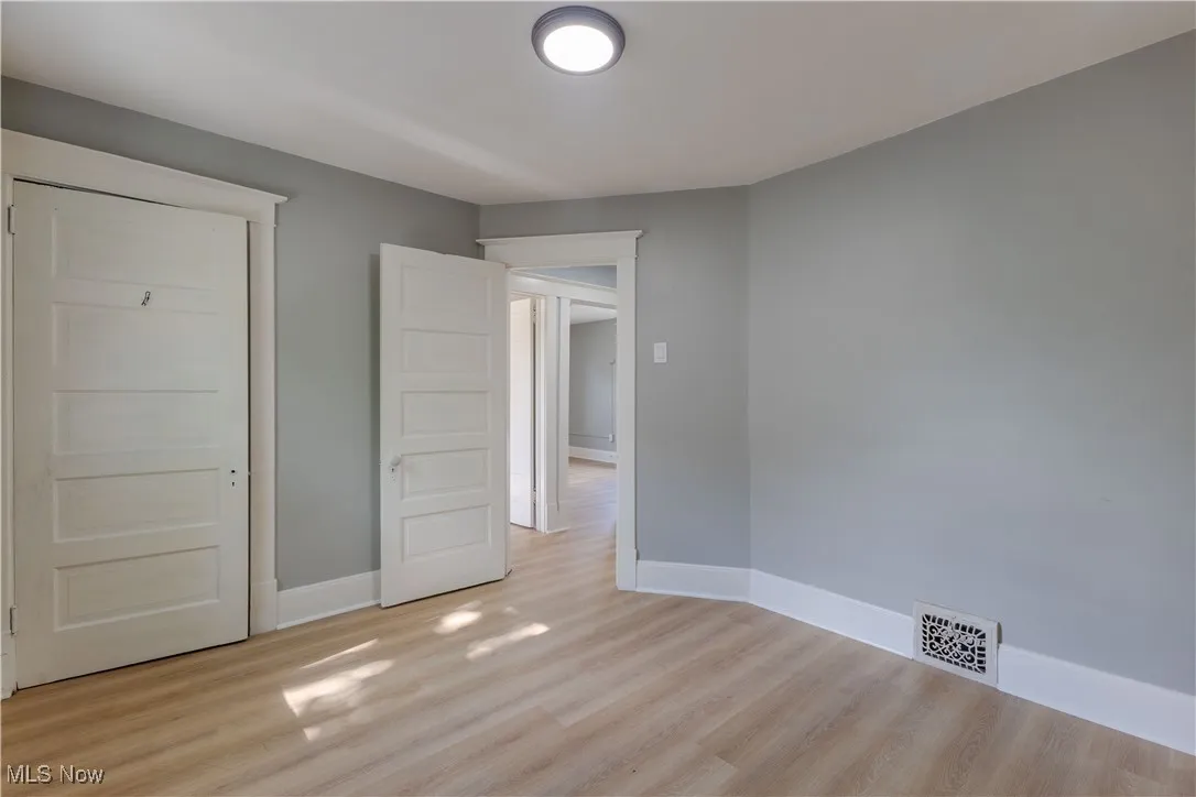 Unfurnished bedroom featuring light wood-type flooring and baseboards