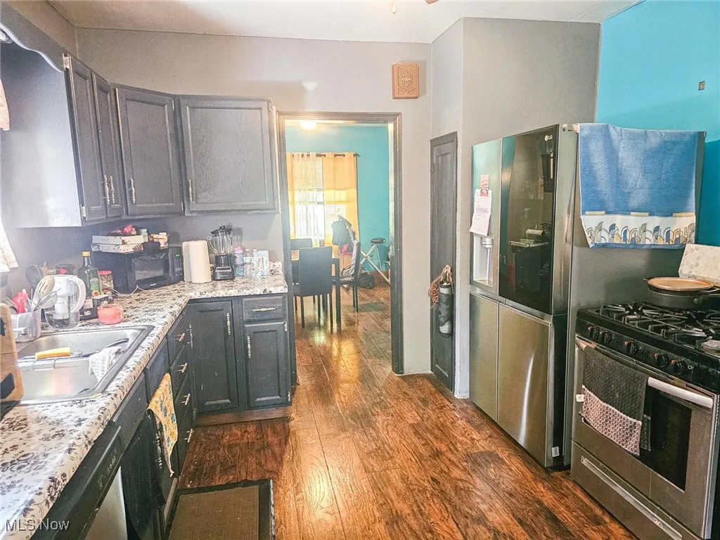 Kitchen featuring appliances with stainless steel finishes, dark wood-style flooring, and a sink