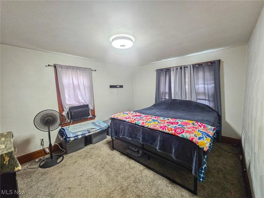 Bedroom with carpet flooring, baseboards, and cooling unit
