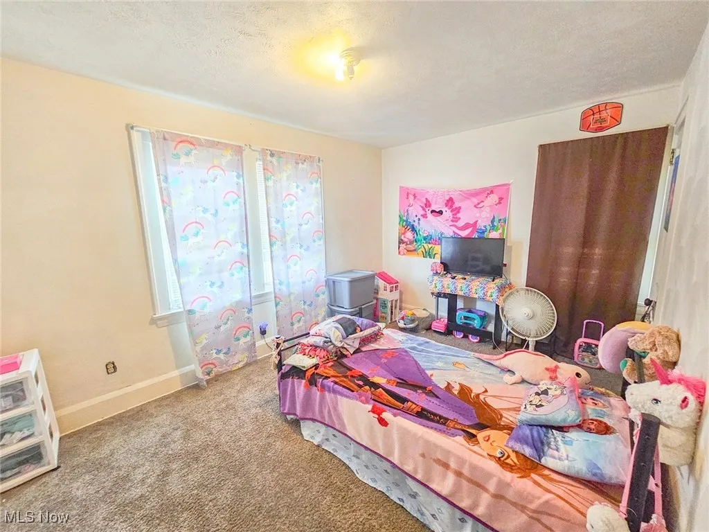 Bedroom with carpet floors, baseboards, and a textured ceiling