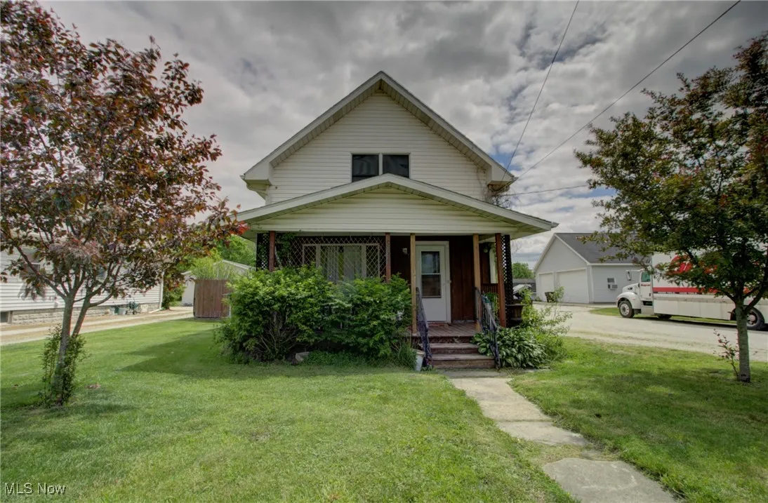 View of front of property with covered porch and a front lawn