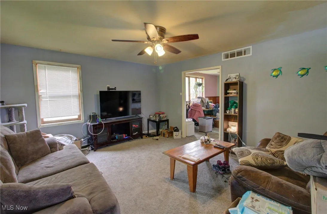 Living room featuring ceiling fan and carpet flooring