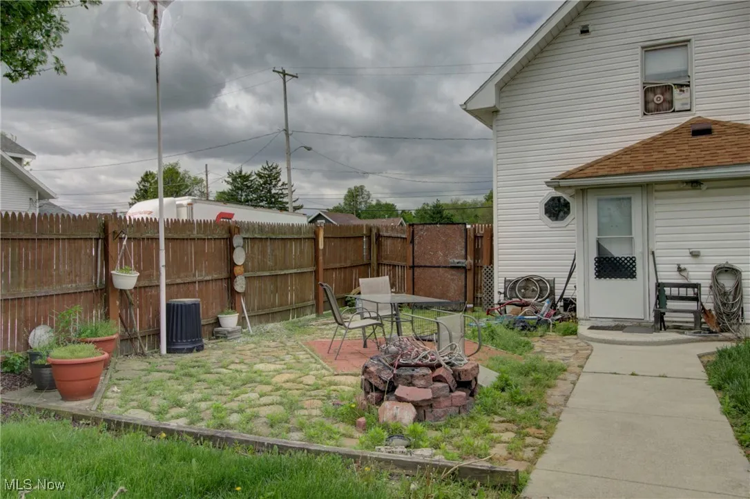 View of yard featuring an outdoor fire pit, cooling unit, and a patio