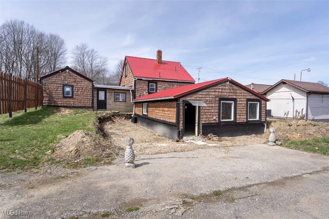 View of front facade featuring a chimney and metal roof