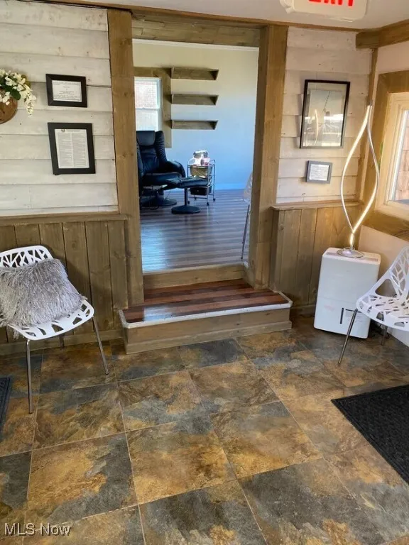 Hallway with wood walls and stone finish floors