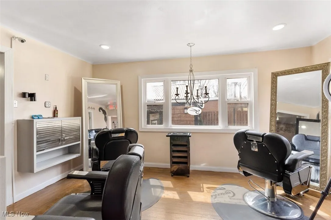 Office space featuring light wood finished floors, baseboards, a chandelier, and recessed lighting