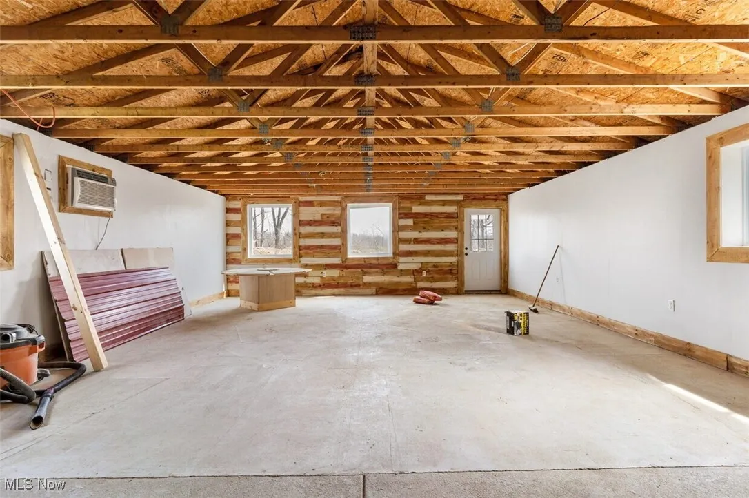 Garage featuring a wall mounted AC and baseboards