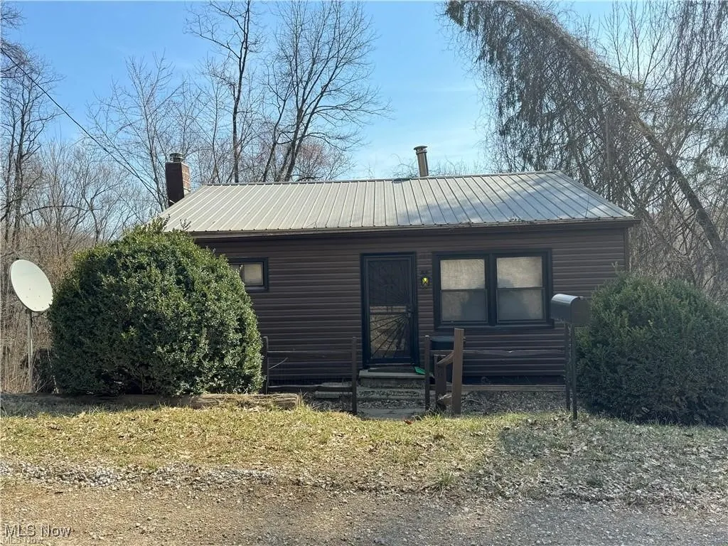 View of front of home with a chimney and metal roof
