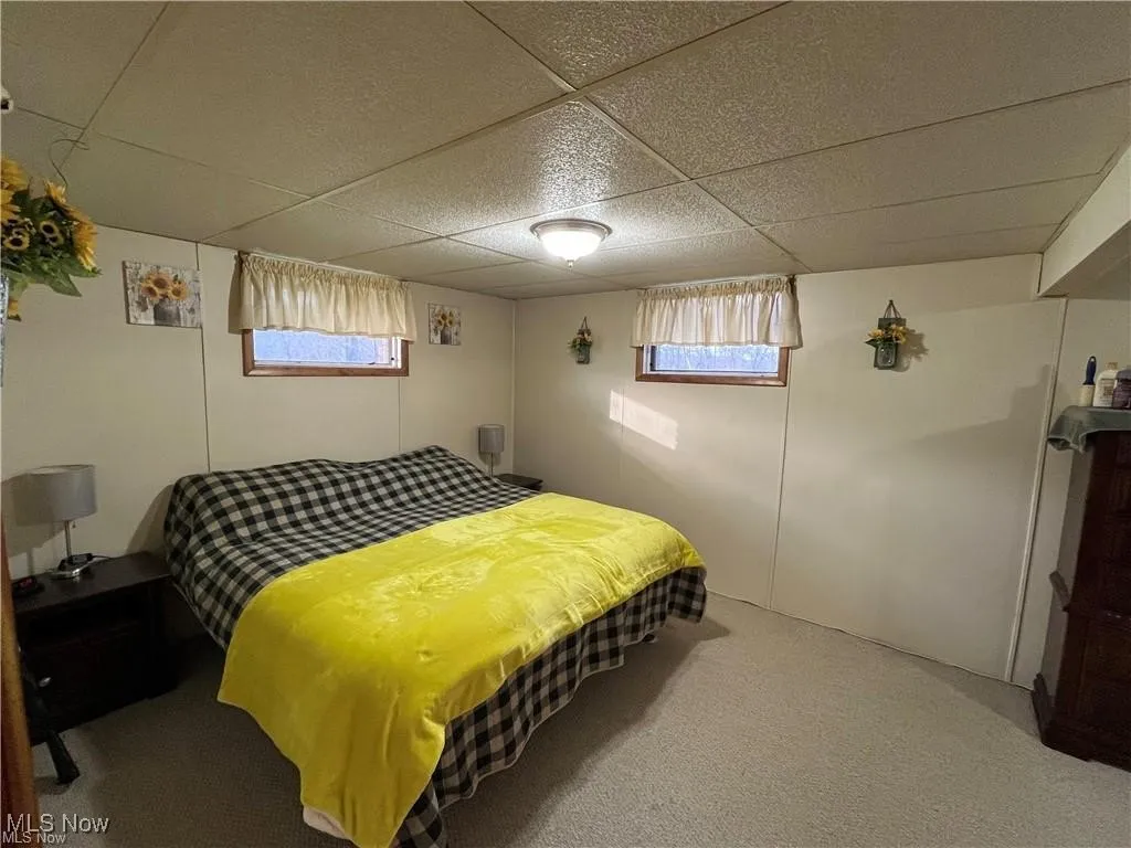 Bedroom featuring multiple windows, a paneled ceiling, and carpet floors