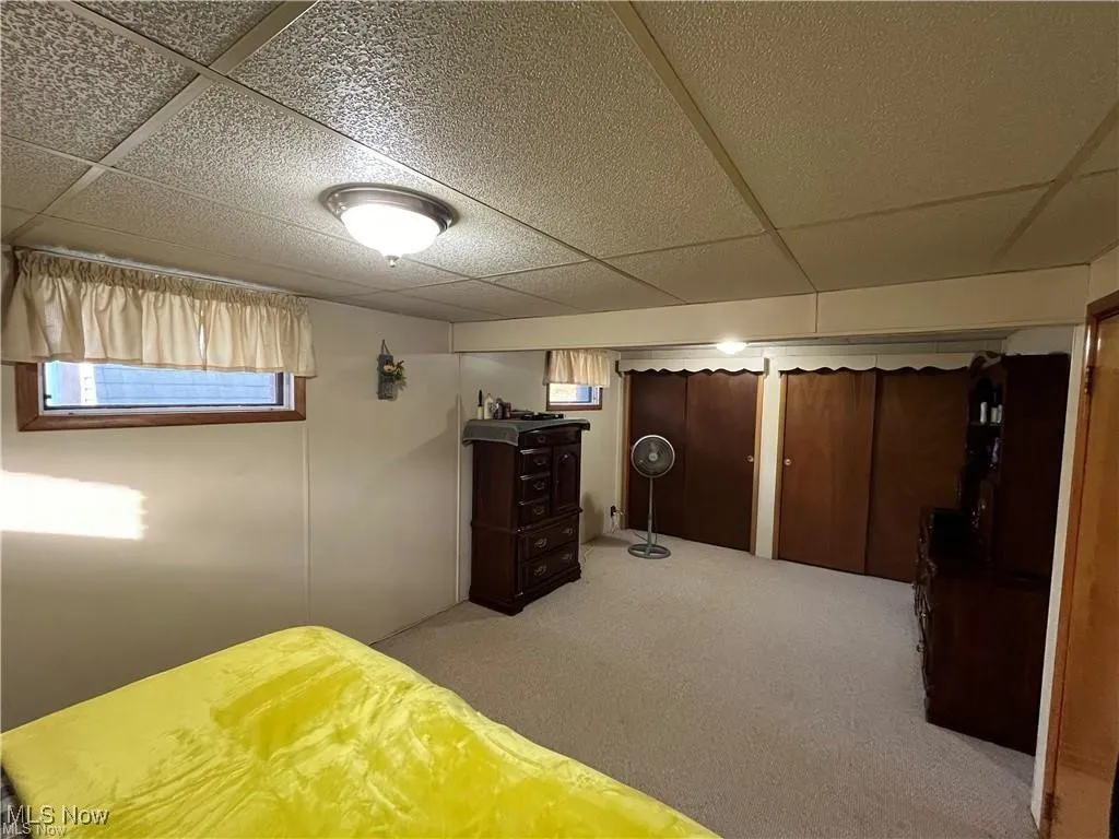 Bedroom featuring a drop ceiling and carpet