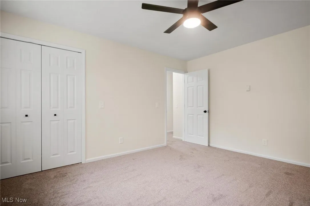 Unfurnished bedroom featuring carpet flooring, baseboards, a closet, and ceiling fan