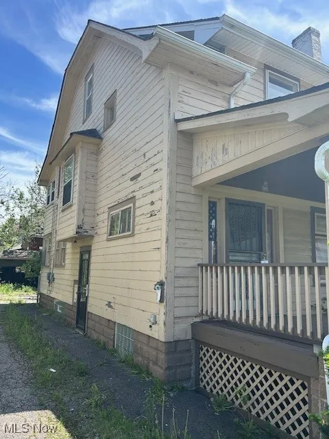 View of side of home featuring covered porch