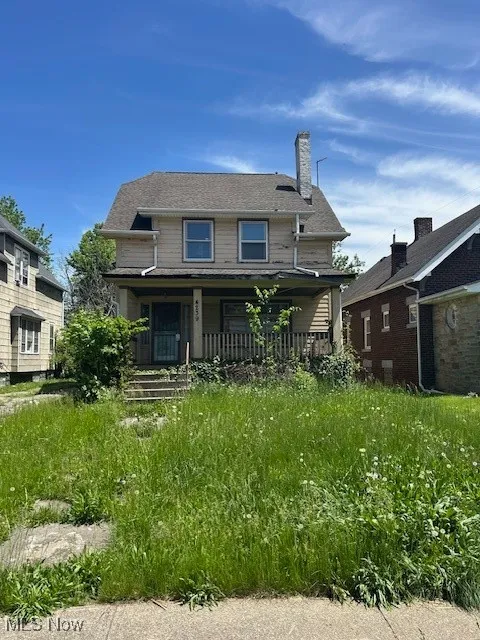 Back of property featuring covered porch