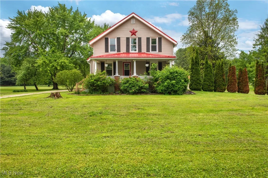 View of front of house with covered porch and a front lawn
