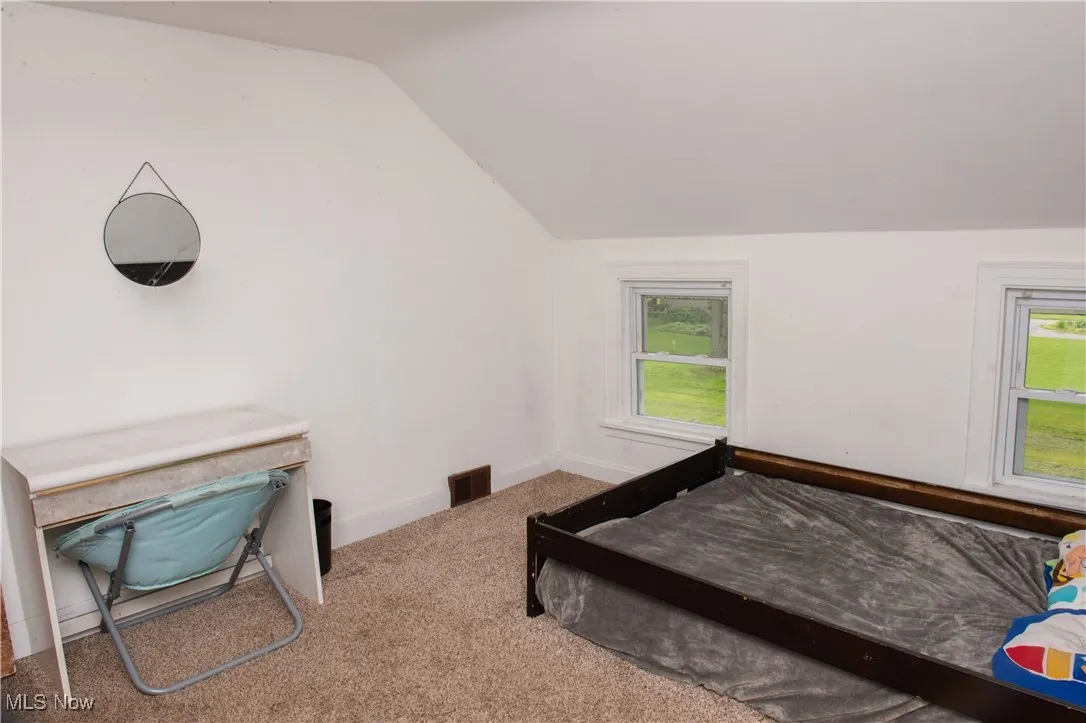 Bedroom with lofted ceiling and carpet floors