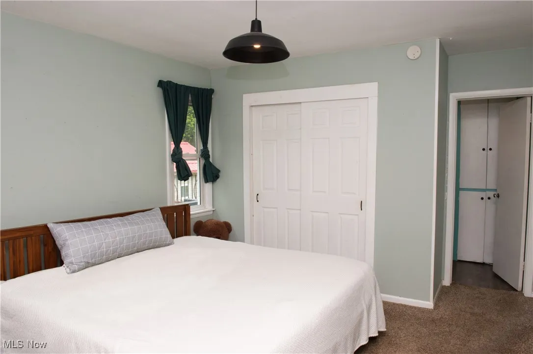 Bedroom with carpet, a closet, and baseboards