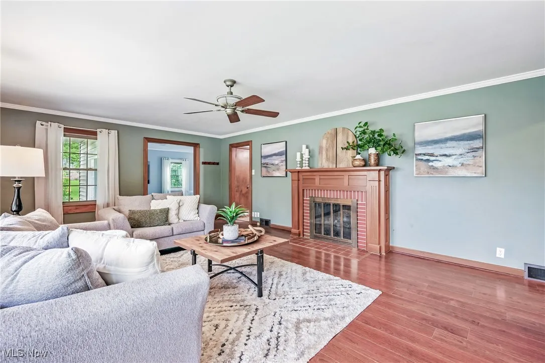 Living room with overhead fan  showing entrance from kitchen and dining area.