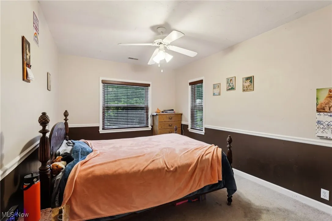 Carpeted bedroom featuring a ceiling fan and baseboards
