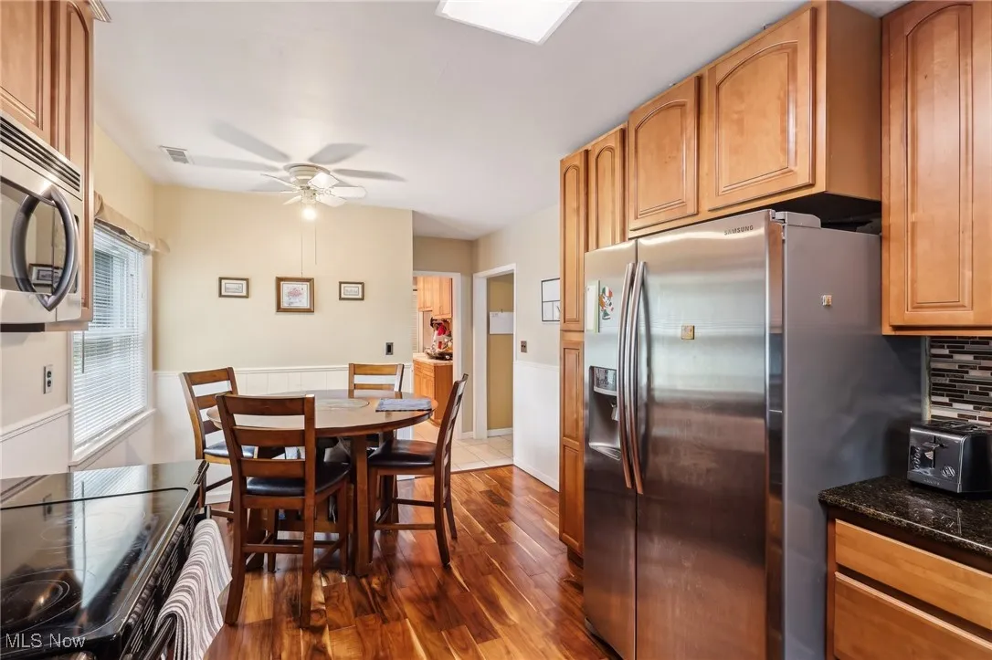 Dining space with dark wood-type flooring and a ceiling fan