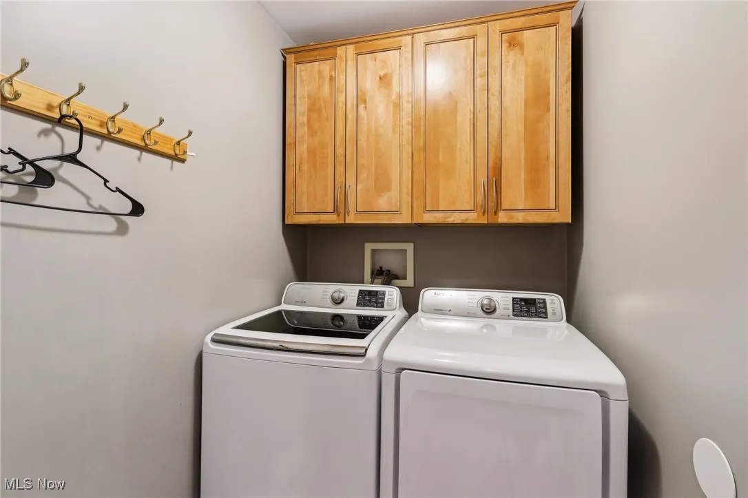 Washroom with cabinet space and washing machine and dryer