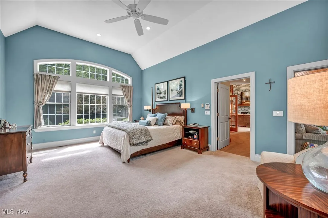 Carpeted bedroom with a ceiling fan, high vaulted ceiling, and recessed lighting