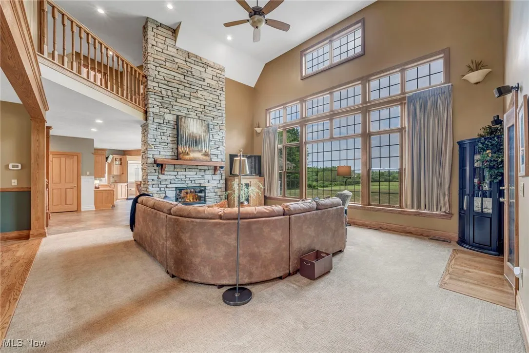 Living area featuring a high ceiling, a fireplace, recessed lighting, and ceiling fan
