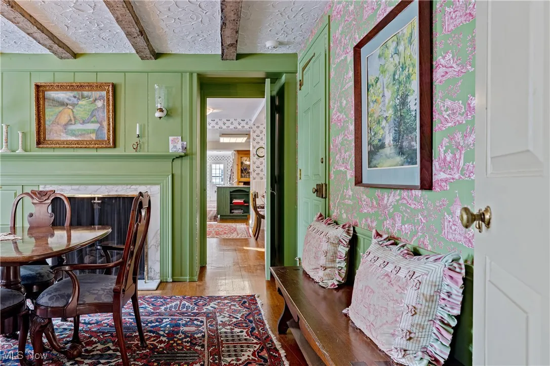 Dining area with light wood-type flooring and beam ceiling