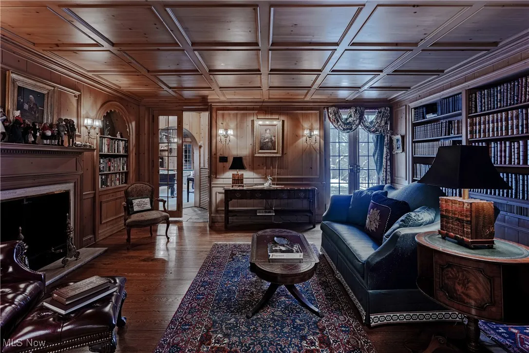 Living room featuring french doors, wood walls, coffered ceiling, and wooden ceiling