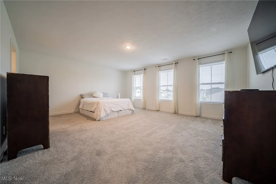 Bedroom featuring carpet and baseboards