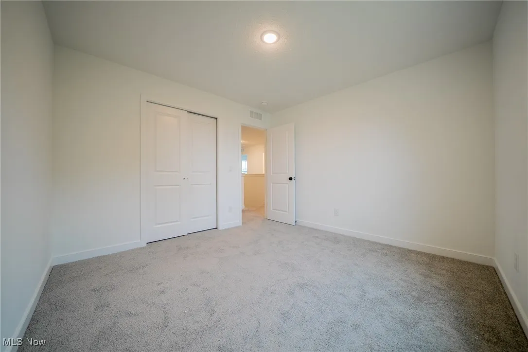 Unfurnished bedroom with carpet, baseboards, and a closet