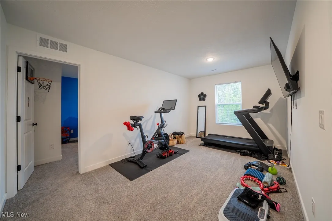 Workout area with carpet floors and baseboards