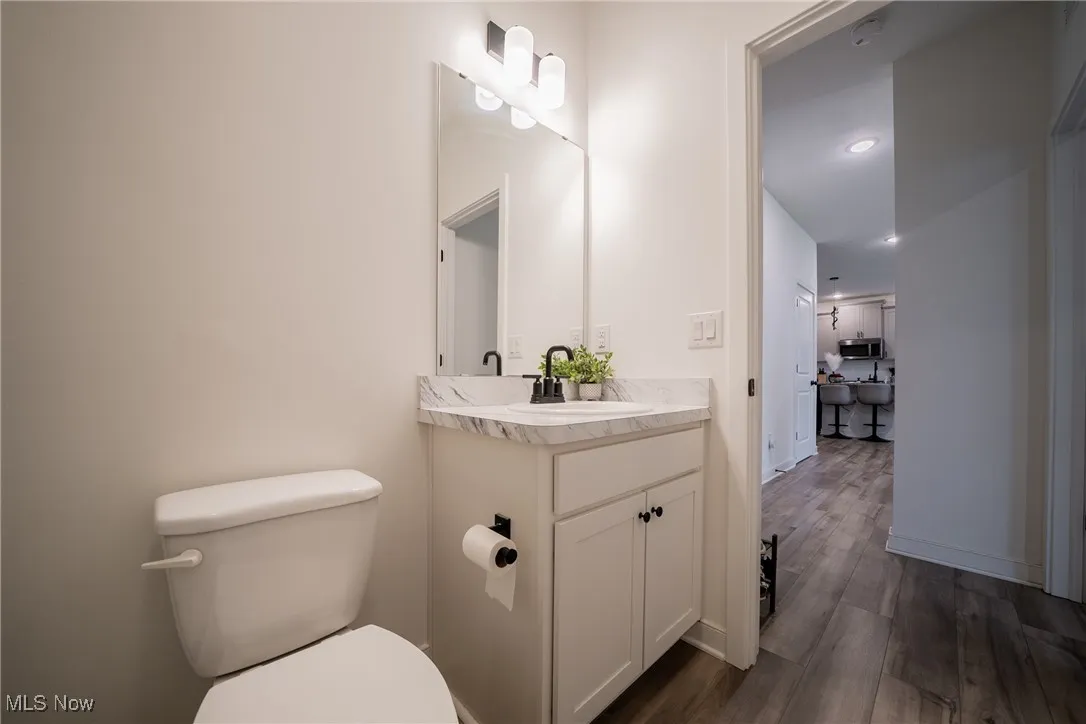 Bathroom with vanity, toilet, and wood finished floors