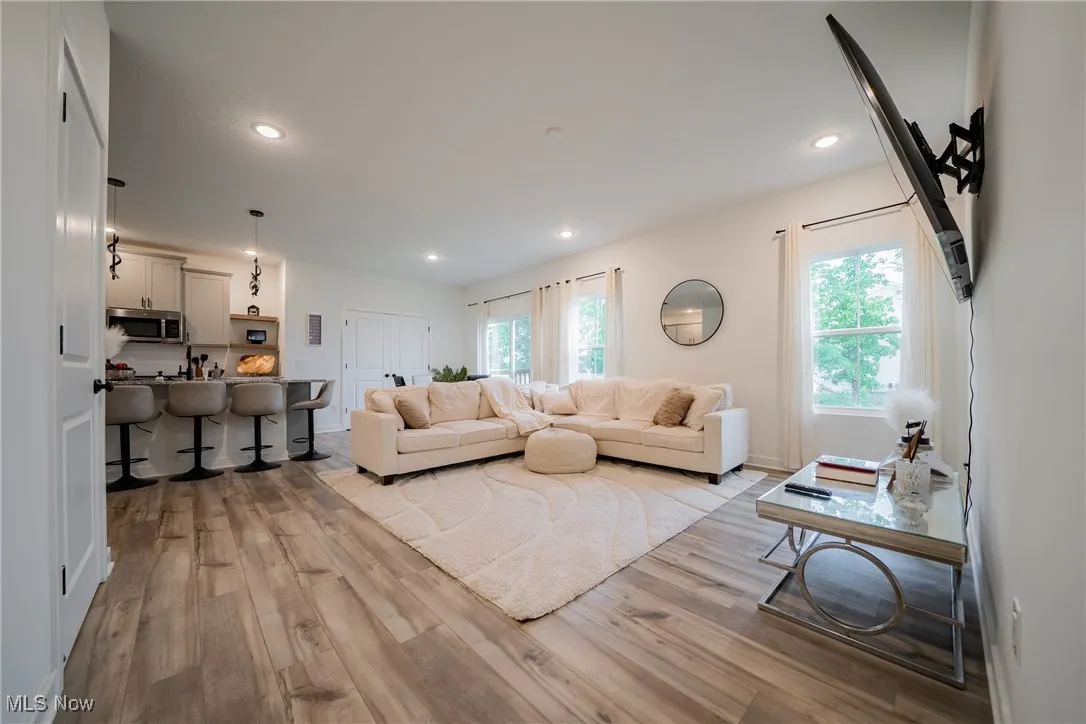 Living area with light wood-style floors and recessed lighting