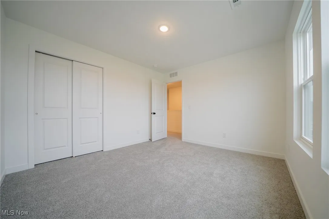 Unfurnished bedroom featuring carpet, baseboards, and a closet
