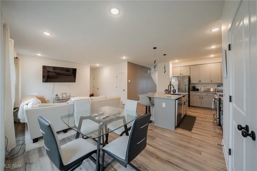 Dining area with light wood finished floors and recessed lighting