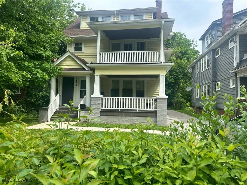 View of front of home featuring a balcony and covered porch